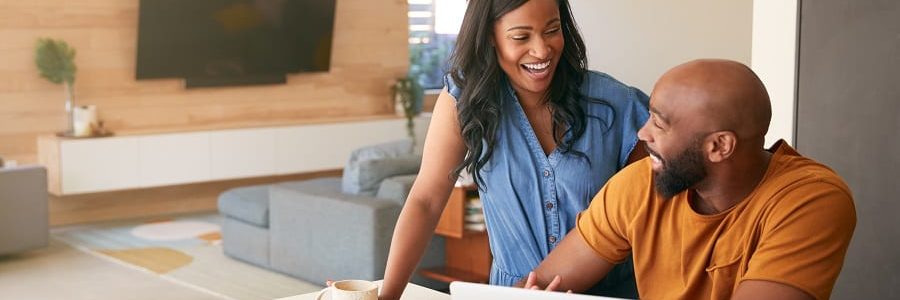 Smiling couple using laptop to check private loans | Financial Information | Private Loans